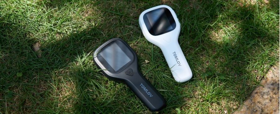 Tomlov P10 2" LCD Digital Microscope is on the grass.